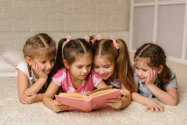 istock Group of kid lay down on floor and reading tale book 1207474880