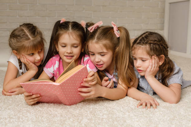 istock Group of kid lay down on floor and reading tale book 1207474966