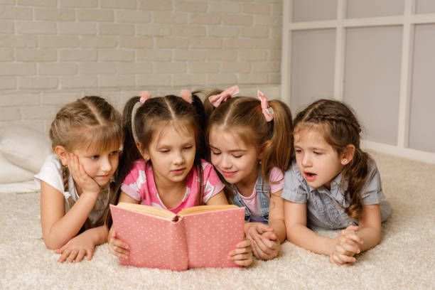 istock Group of kid lay down on floor and reading tale book 1207475008