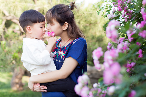 young beautiful chinese woman and her young son playing in the park