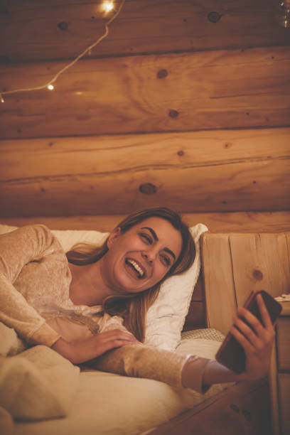 funny video call to catch up with friends - rustic bedroom cabin indoors imagens e fotografias de stock