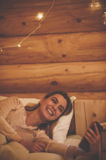 funny video call to catch up and wish goodnight - rustic bedroom cabin indoors imagens e fotografias de stock