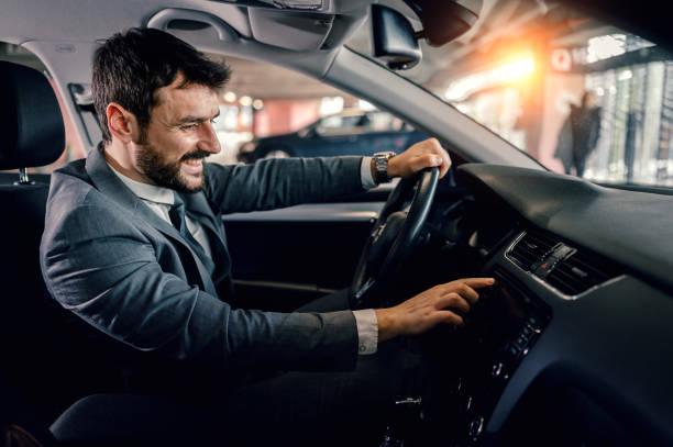 istock Man turning on his car radio while driving 1207476891