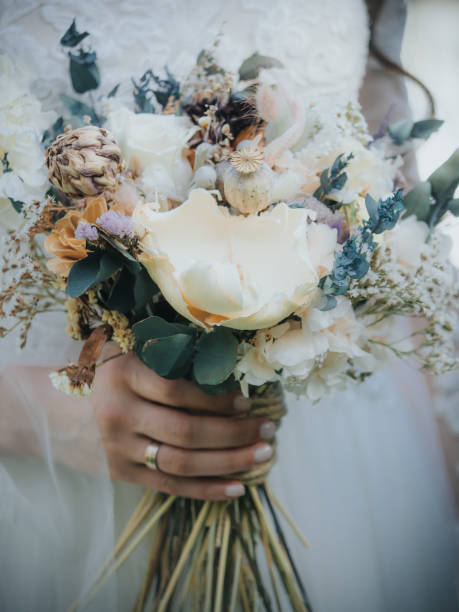 istock Brides with bridal flowers in their hands 1207477815