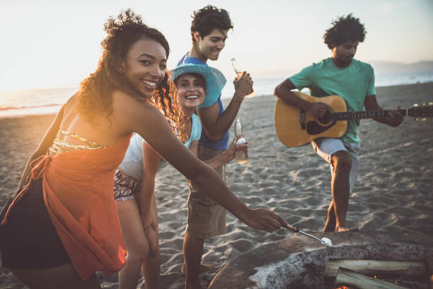 istock Group of friends having fun on the beach making a bonefire 1207480570