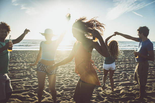 istock Group of friends having fun on the beach making a bonefire 1207481200
