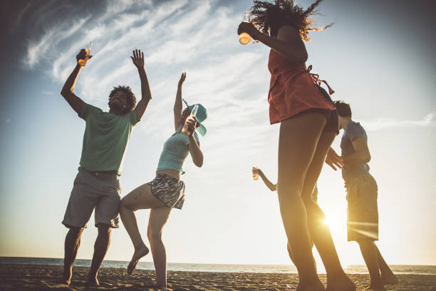 istock Group of friends having fun on the beach making a bonefire 1207481328