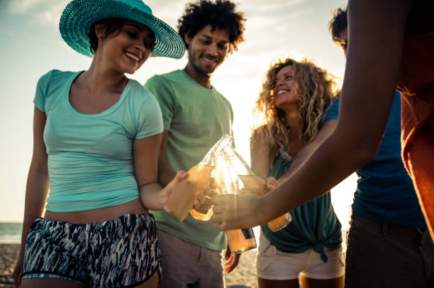 istock Group of friends having fun on the beach making a bonefire 1207481509