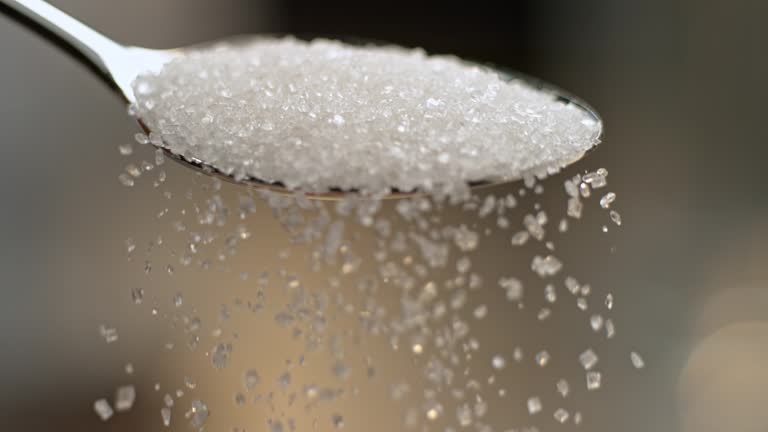 SLO MO LD White sugar falling off a spoon