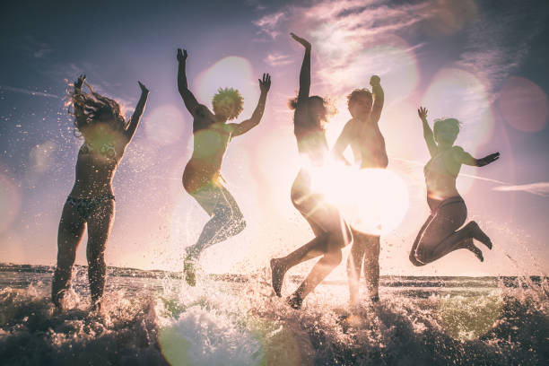 istock Group of friends having fun on the beach making a bonefire 1207481641