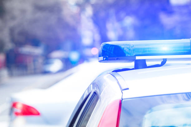 coche de policía con luces azules en la escena del crimen en el tráfico / entorno urbano. - social security flash fotografías e imágenes de stock