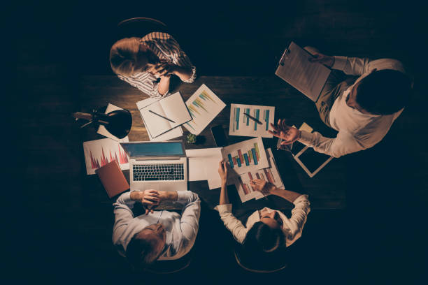 istock Top above high angle view of smart clever hardworking people top executive managers working with data preparing report presentation deadline at late night workplace workstation 1207486547