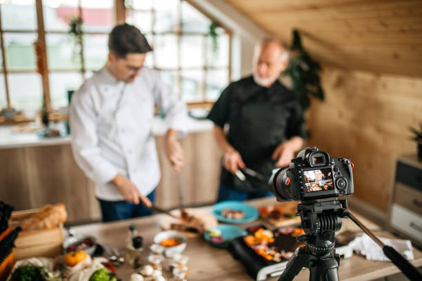 istock Camera Filming Young Man and his Father Preparing Lunch At Kitchen 1207487126