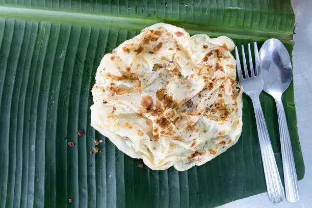 Photo of Roti canai or paratha on banana leaf, favourite Malaysian food