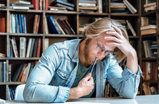 Serious smart focused man student writer glasses home library desk hold pen pencil mind pose think over task do test solve problem hand write diploma project paper study exam education concept serio inteligente enfocado hombre estudiante escritor gafas home biblioteca escritorio sostener lápiz pluma pensamiento pensamiento sobre tarea hacer prueba resolver problema a mano escribir proyecto de diploma estudio de estudio de estudio de estudio con
