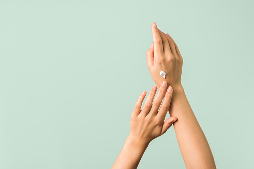 primer plano de las manos tiernas de una mujer joven con crema hidratante. protección de la piel de primavera photo