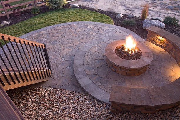 Bueatiful backyard firepit Circular fire pit at dusk on a flagstone patio fire pit photos stock pictures, royalty-free photos & images