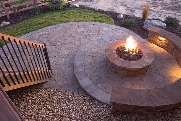 Circular fire pit at dusk on a flagstone patio