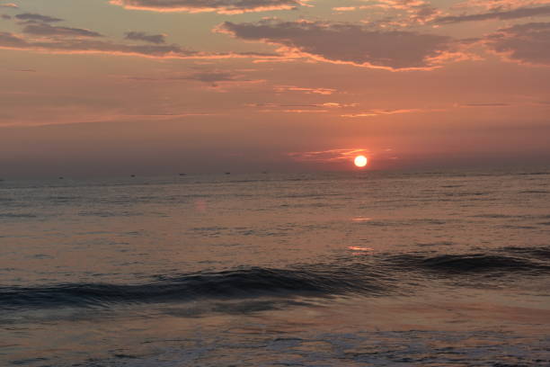 istock sun setting in a ocean with small waves and beautiful sky 1207493740