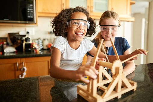 Shot of little girls playing with a catapult at home