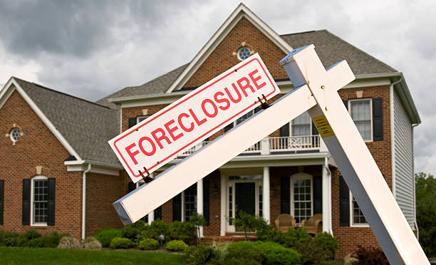 Foreclosure sign in front on modern house Leaning foreclosure sign in front of a modern single family home on a cloudy cold day foreclosure stock pictures, royalty-free photos & images