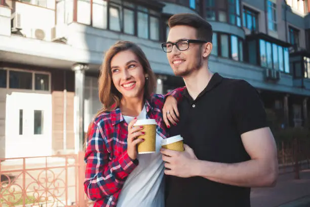Photo of Portrait of happy couple walk on the street with coffee
