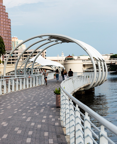 Tampa, Florida, USA - People walking and running on the River Walk along the water in Tampa Florida.