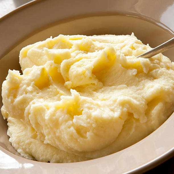 Mashed Potato Mashed potato with spoon, in serving bowl. mashed potatoes stock pictures, royalty-free photos & images