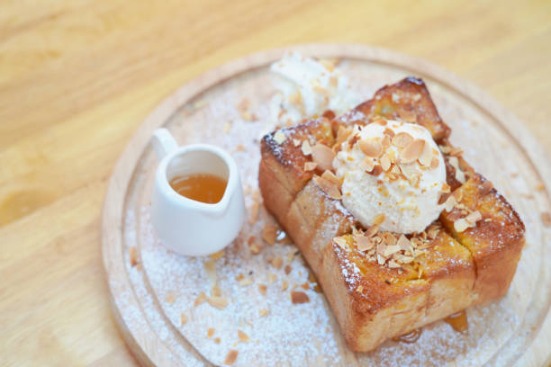 istock Honey toast topped with nuts and cups with honey on table 1207499472