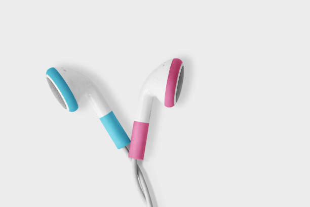 blue and pink earphones opposite each other on white background - concept of communication problems between men and women (gender communication) - sex and reproduction audio imagens e fotografias de stock