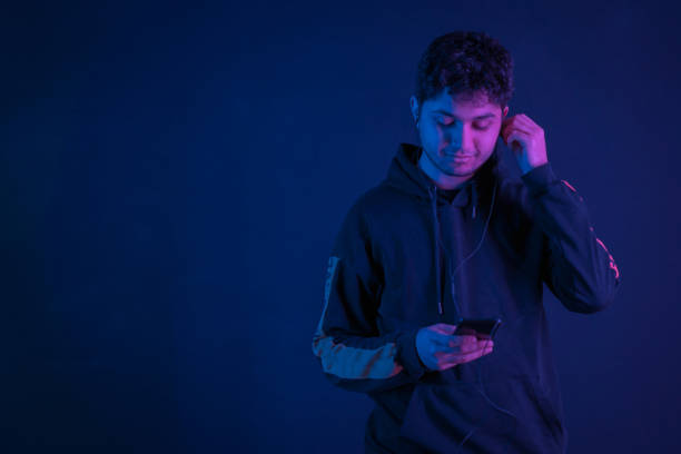 istock Portrait of young  man using smartphone in neon light 1207501976