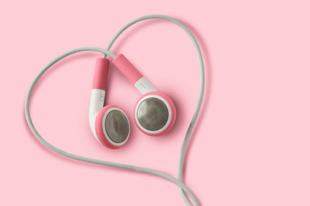 różowe słuchawki w kształcie serca na różowym tle - koncepcja miłości, słuchania i wsparcia dla kobiet - sex and reproduction audio zdjęcia i obrazy z banku zdjęć