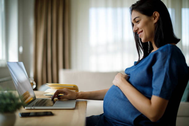 istock Pregnant woman using laptop at home 1207504227