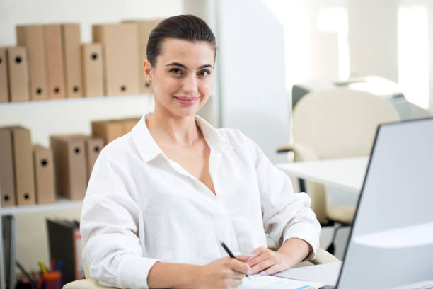 istock Young beautiful business woman with computer 1207504748