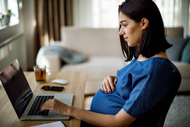 istock Pregnant woman using laptop at home 1207504963