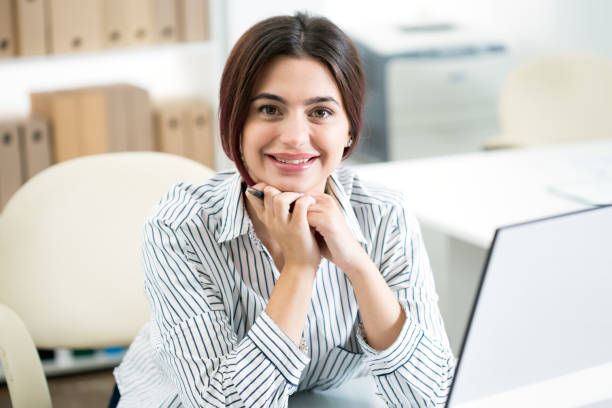 istock Young beautiful business woman with computer 1207505115