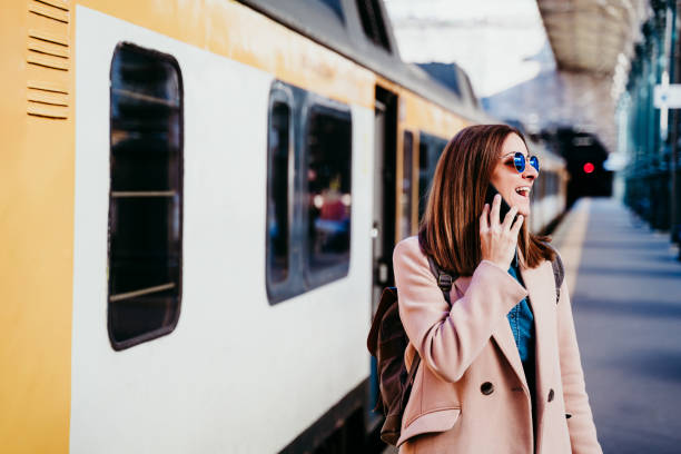 istock young woman at train station using mobile phone. Travel concept 1207507108