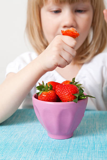 istock LIttle girl eating strawberries 120750866