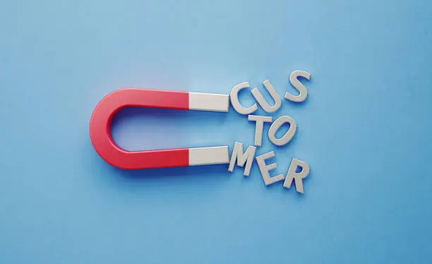 Customer text gravitated towards a red horseshoe magnet on blue background. Horizontal composition with copy space.