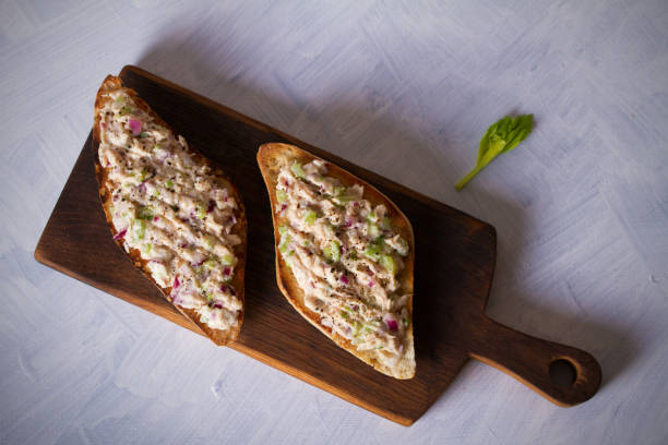 まなまぶしの上のマグロサラダサンドイッチ、白い背景 - tuna salad sandwich ストックフォトと画像