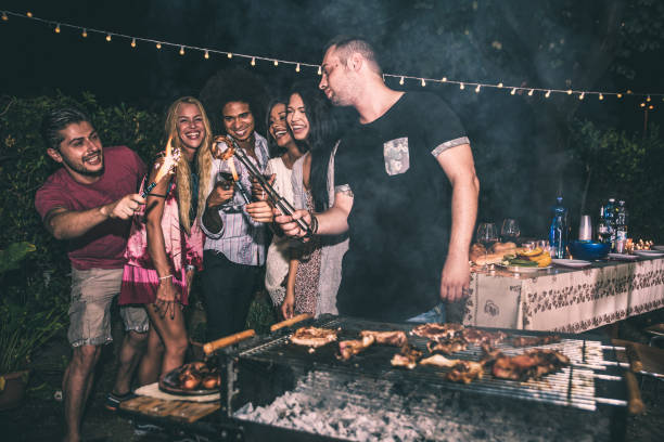 istock Group of friends making barbecue in the backyard at dinner time 1207513318