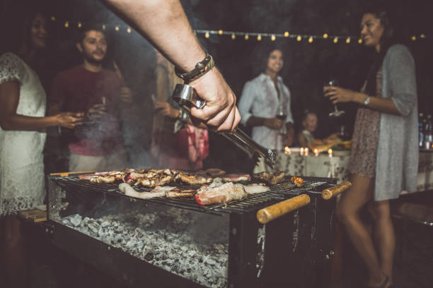 istock Group of friends making barbecue in the backyard at dinner time 1207513483