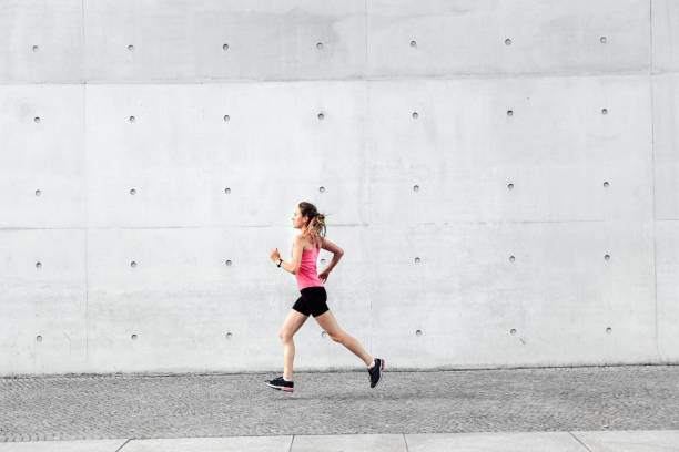 istock young sportswoman running in front of concrete wall 1207513558