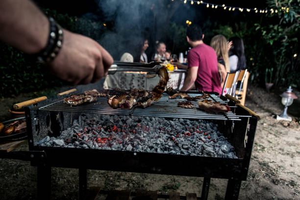 istock Group of friends making barbecue in the backyard at dinner time 1207513769