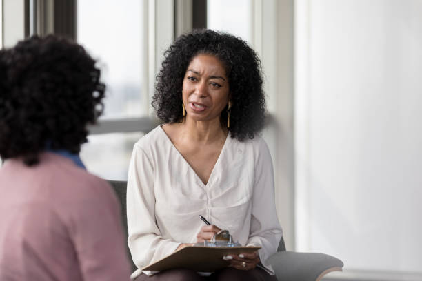 istock With concerned look, mature therapist asks patient question 1207514076