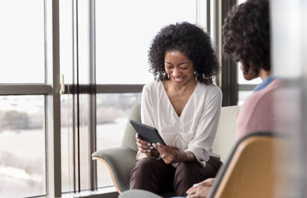 istock As client speaks, therapist smiles and looks at digital tablet 1207514090