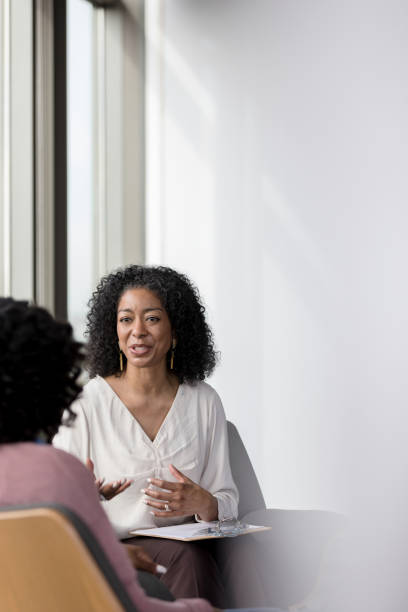 Mature counselor talking with female patient