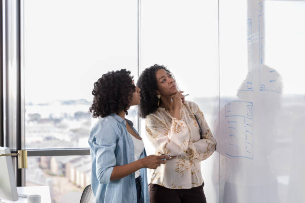 istock Two female business colleagues brainstorming project ideas 1207514193