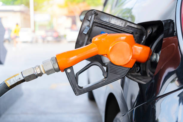fuel nozzle filled car with fuel fuel nozzle filled car with fuel, car being filled gasoline at gas station, Pumping gasoline fuel in black car at gas station , Gas pump nozzle. armored vehicle photos stock pictures, royalty-free photos & images