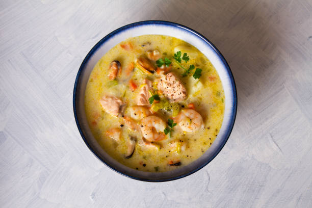 istock Bowl of seafood chowder with salmon on white background 1207517567